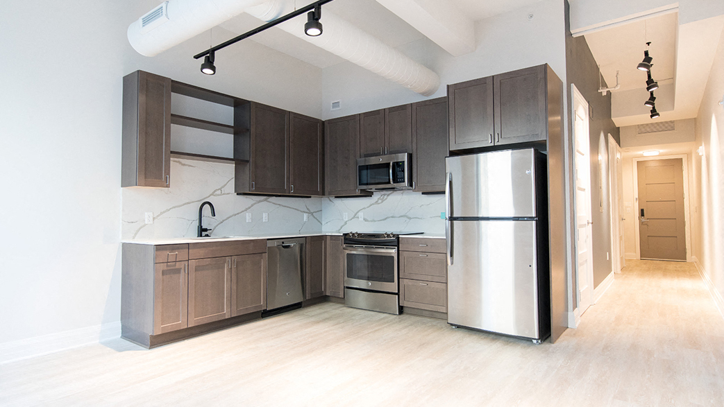a large kitchen with stainless steel appliances and wooden cabinets